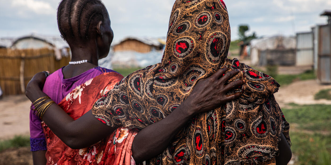 Two women look out within an IDP site in northern South Sudan, 2024. | Photo credit: Alioune Ndiaye/OCHA.
